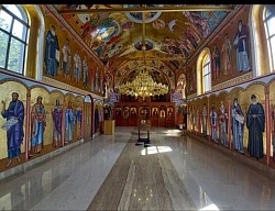 поглед на унутрашњост храма са упаљеним полијелејем и богатим фрескописом на сводовима