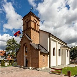 панорама храма светог архангела гаврила у чајетини са звоником и белом фасадом, поглед на главни улаз цркве из црквене порте, архитектура старе цркве у чајетини са три лучна прозора на фасади