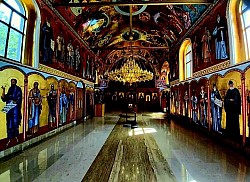 престоне иконе и дуборезни иконостас, унутрашњост храма у чајетини обасјана светлошћу кандила и полијелеја у Чајетини