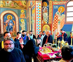 Заједничка молитва и поклоњење групе свештеника Архијерејских намесништава ужичког и рачанског пред Часном Трпезом у олтарском делу Храма Преображења Господњег на Златибору. Свештеници се клањају и целују богослужбене предмете у присуству духовника, са видљивим свећама и златним посуђем током братокрајне исповести