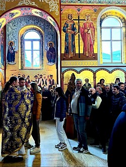 Sveta tajna pričešća: Red vernika, dece i odraslih, koji u miru prilaze putiru kako bi primili sveto pričešće iz ruku sveštenika u hramu u Čajetini, simbolizujući jedinstvo u veri