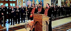 Унутрашњост Храма Преображења Господњег на Златибору током служења свечаног парастоса за пострадале припаднике Посебне јединице полиције. Светим чином чинодејствују protojerej Dejan Vasiljević, starešina hrama na Zlatiboru, protojerej Petar Lazić, starešina hrama Svetog arhangela Gavrila u Čajetini, i đakon Nenad Srećković. Свештенослужитељи су у свечаним црвеним фелонима са златним везом, окренути ка народу. Лево од њих стоје високи официри и појединци са ордењем на грудима, док се у позадини види већи број окупљених верника под велелепним златним хоросом и богатим фрескописом храма