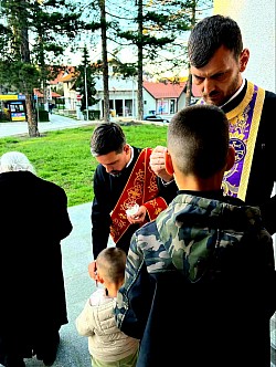 Детаљан приказ православног обреда седмоструког помазивања верника освећеним јелејем током Свете тајне јелеосвећења у Чајетини. Свештеници и јеромонаси из манастира Увац и Дубрава помазују вернике освећеним уљем седам пута за опроштај грехова и телесно исцељење. Лица верника и деце из Чајетине и са Златибора испуњена побожношћу током помазивања на чесним местима главе и руку. Овај свети чин врши се у склопу Страсне седмице и припреме за Васкрсење Христово у храму Светог архангела Гаврила под вођством седам свештенослужитеља