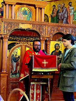 Детаљан приказ јеромонаха из манастира Дубрава и манастира Увац док узносе јеванђељске молитве за оздрављење душе и тела током службе јелеосвећења у цркви у Чајетини. Фокус је на достојанству монашког чина и њиховом молитвеном посредовању док држе упаљене свеће поред отвореног Јеванђеља. Присуство монаштва заједно са парохијским свештенством из Чајетине и Златибора наглашава духовну снагу којом се брани здравље верног народа. Свака реч коју изговарају монаси током читања Јеванђеља одјекује храмом Светог архангела Гаврила, доносећи мир и наду присутним верницима, монахињама из Дубраве и мештанима који су дошли на ову велику молитву на Великој среди